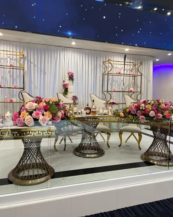 Sweetheart table with colorful floral arrangements in a starlit ballroom