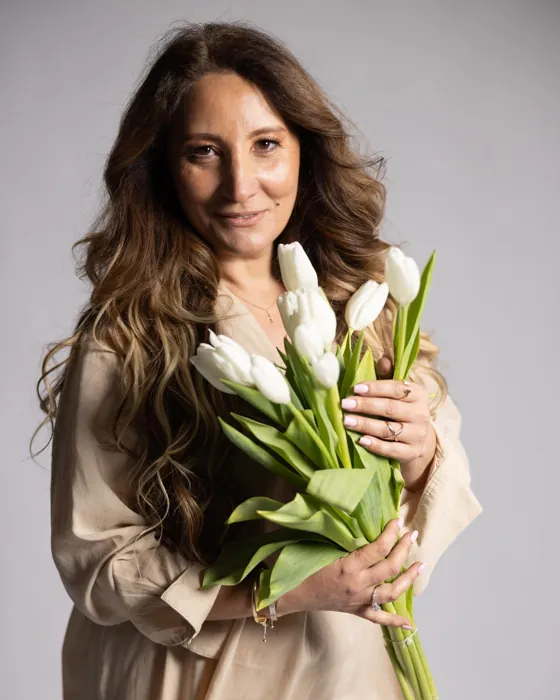 DeLuxe Floral Boutique floral designer holding white tulips