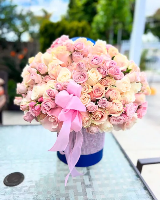 Large dome of pink and peach roses with a pink bow