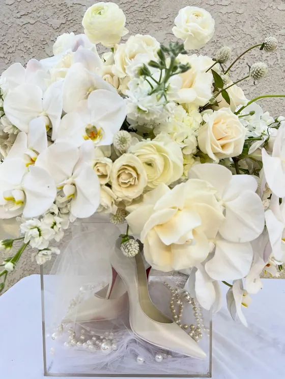 White orchid and garden rose arrangement in an acrylic box