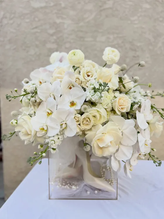 Elegant white roses, orchids and stock in a clear acrylic box